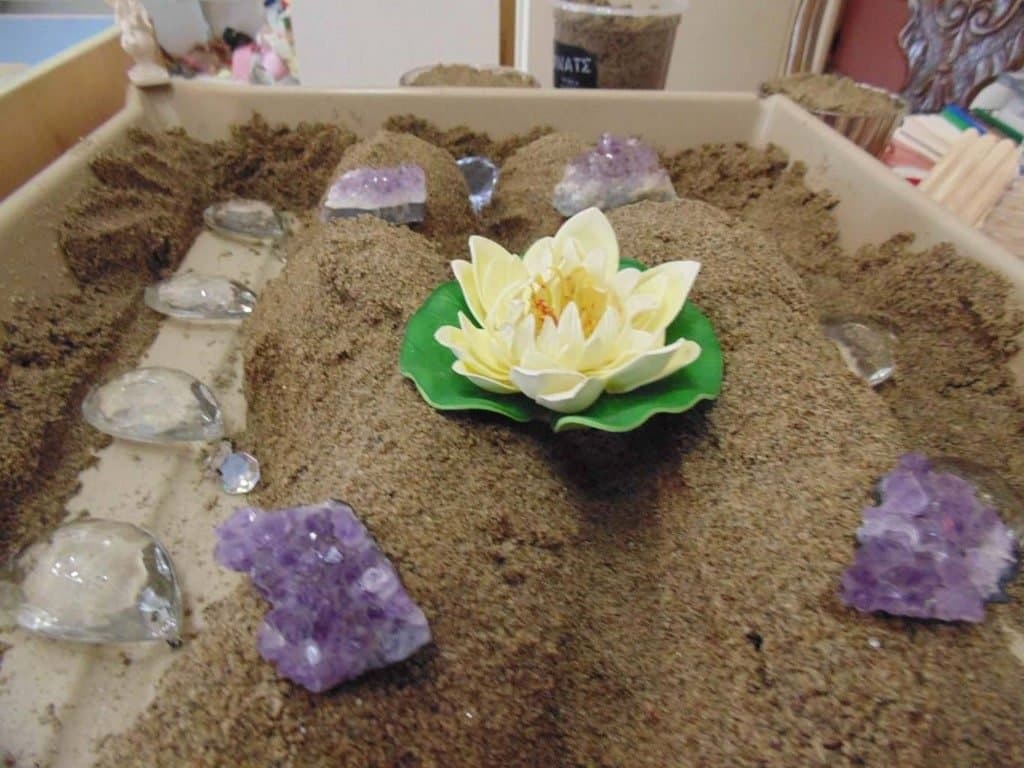 Miniature figures in a sand tray for sandplay therapy